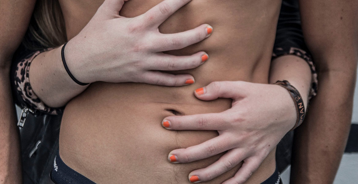 A woman grabbing a mans abs