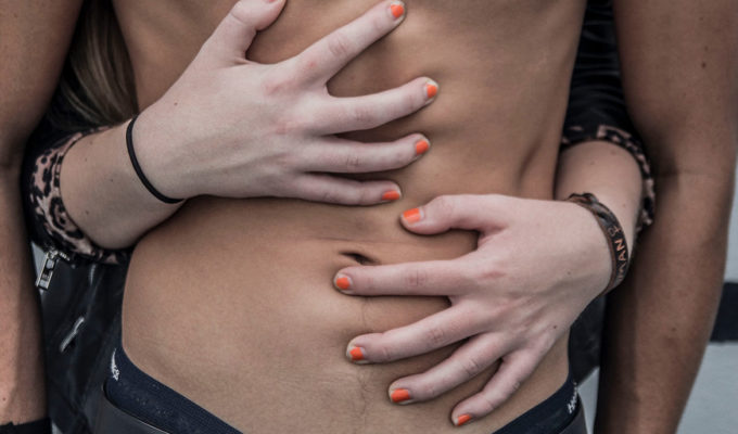 A woman grabbing a mans abs