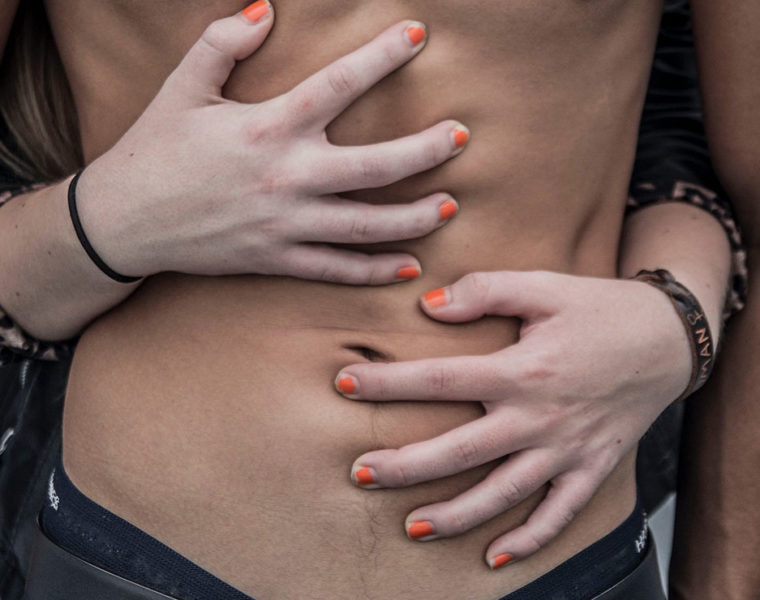 A woman grabbing a mans abs