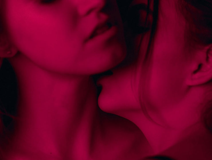 woman kissing another womans neck