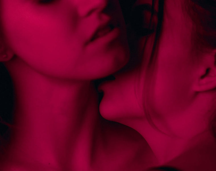 woman kissing another womans neck