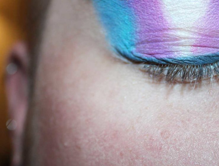 Person with a transgender flag painted on eyelids