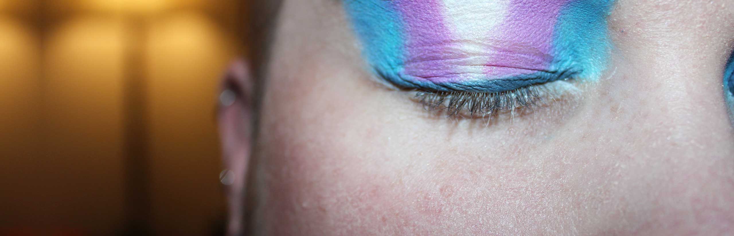 Person with a transgender flag painted on eyelids
