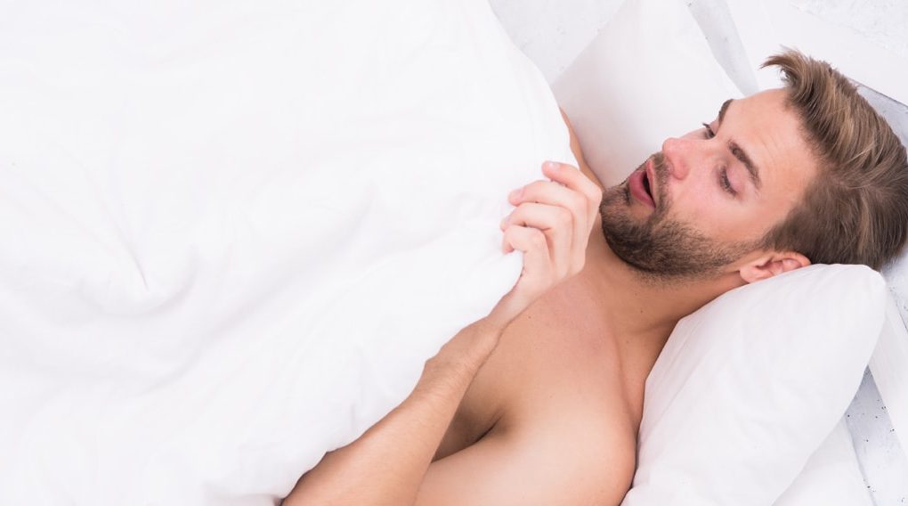 Man laying in bed looking at himself