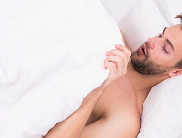 Man laying in bed looking at himself