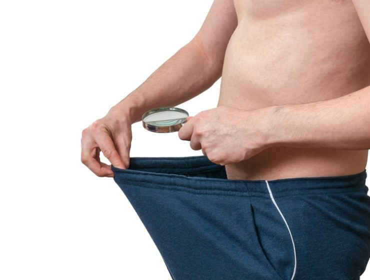 Man looking at himself through a magnifying glass