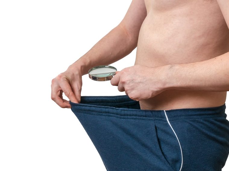 Man looking at himself through a magnifying glass