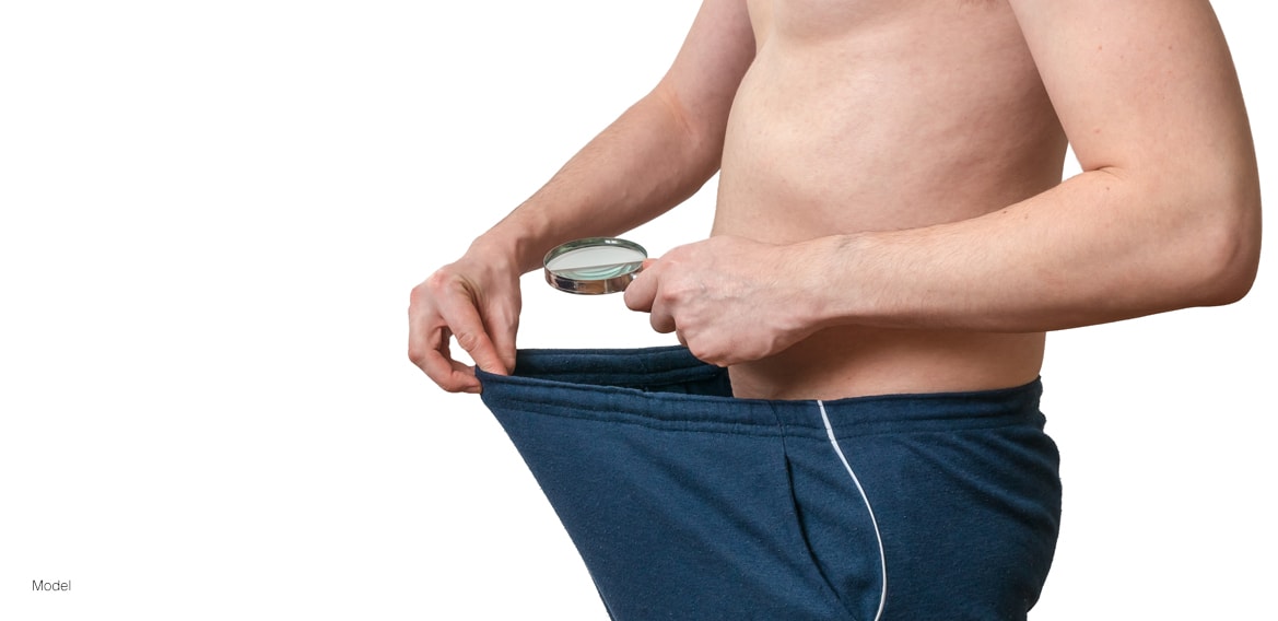 Man looking at himself through a magnifying glass