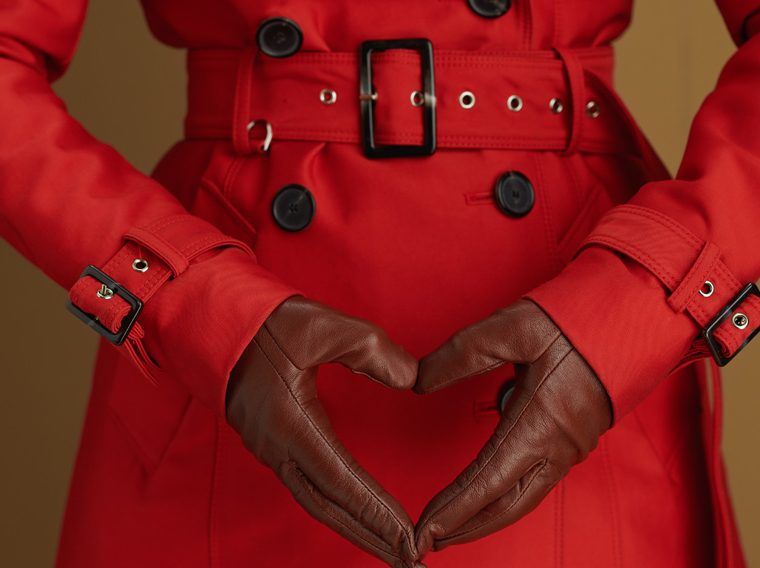 Woman in a red coat with black gloves