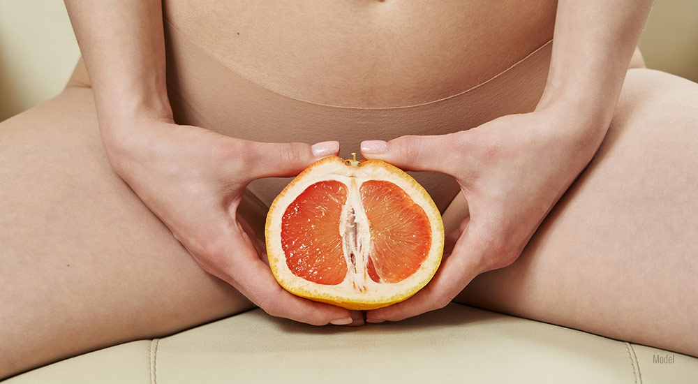Female holding grapefruit in front of her