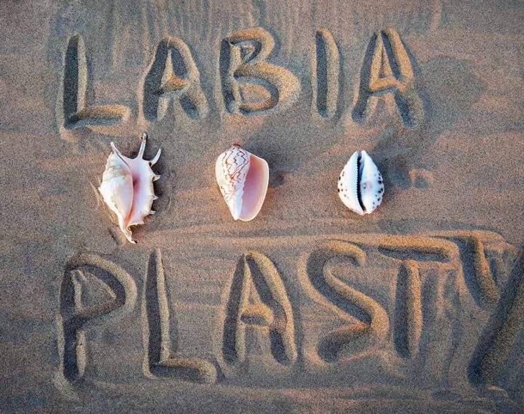 Labiaplasty word written on the sand with shells